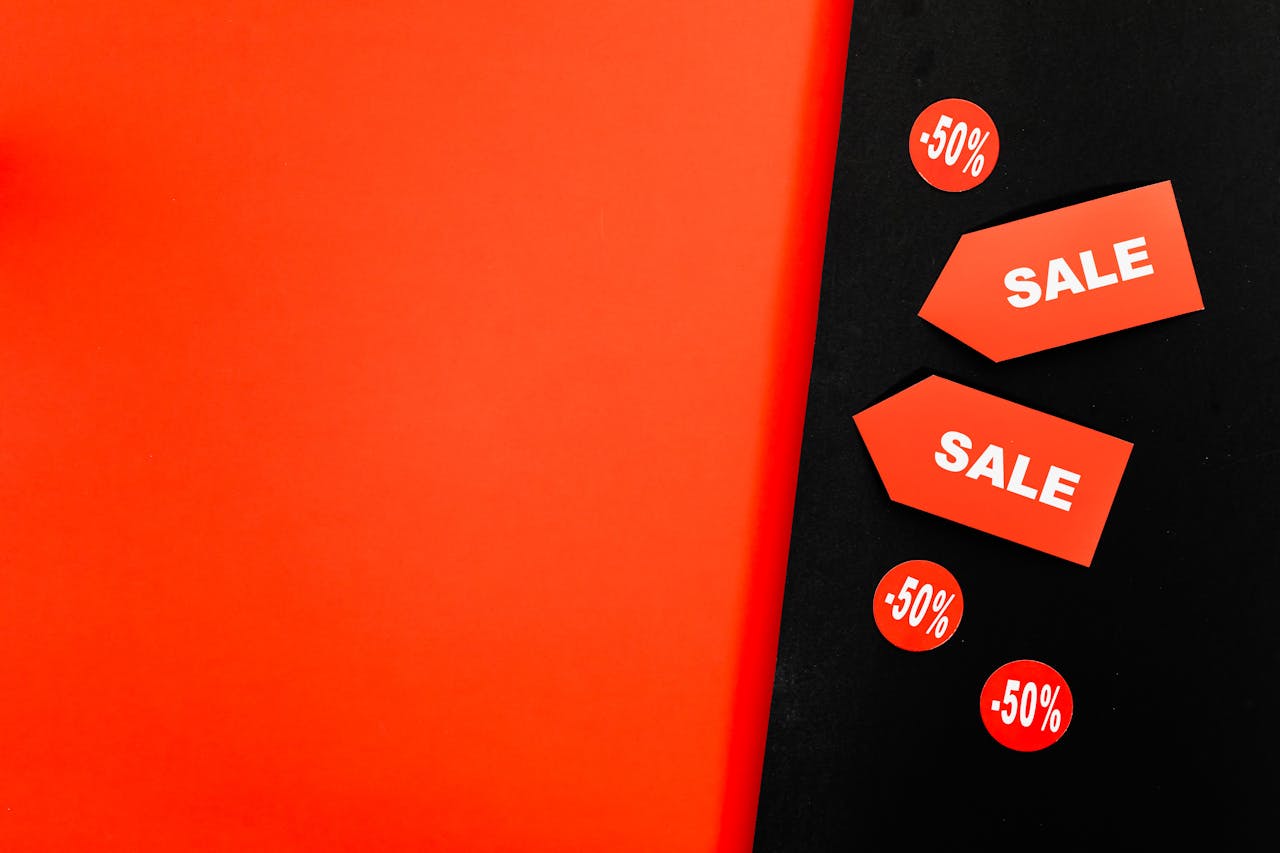 Dynamic red and black background featuring sale tags and 50% discount signs for promotions.